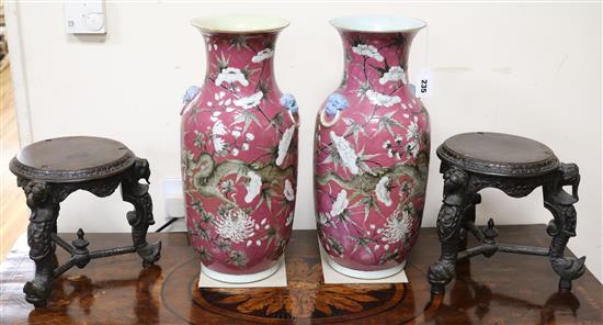 A pair of large 19th century Chinese pink ground dragon vases with carved wood stands
